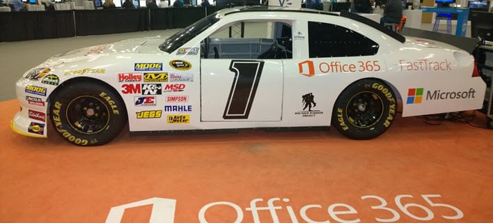 White Office 365 Racecar with many sponsorship stickers, decals, and vehicle wraps.