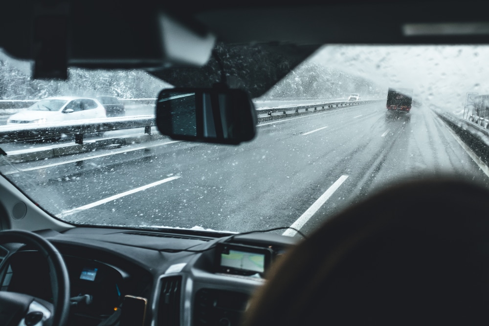 Driving Car in Snowfall. Traveling in Wintertime. Streak-Free Car Windows in the Winter: Tips and Tricks.